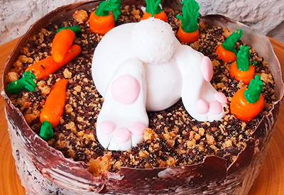 eine Torte mit Karottenverzierung und einem Osterhasen